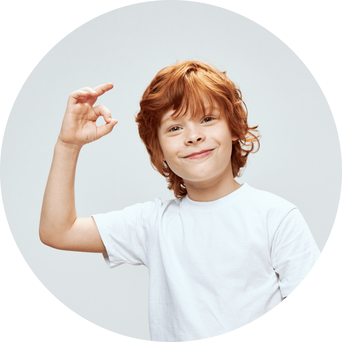 Smiling child with white t-shirt, showing OK sign